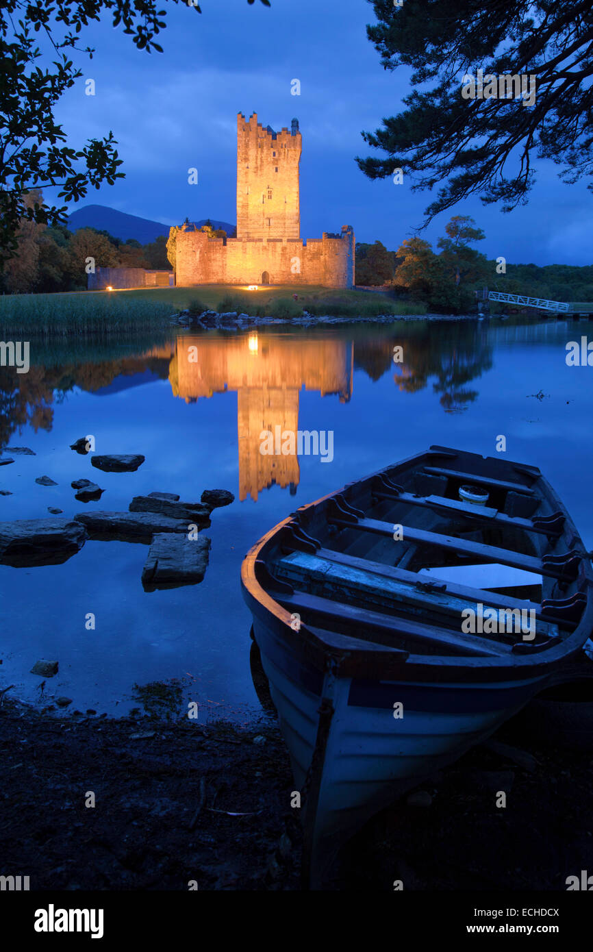 Barco de pesca y el castillo Ross iluminada al anochecer, Lough Leane, Parque Nacional de Killarney, condado de Kerry, Irlanda. Foto de stock