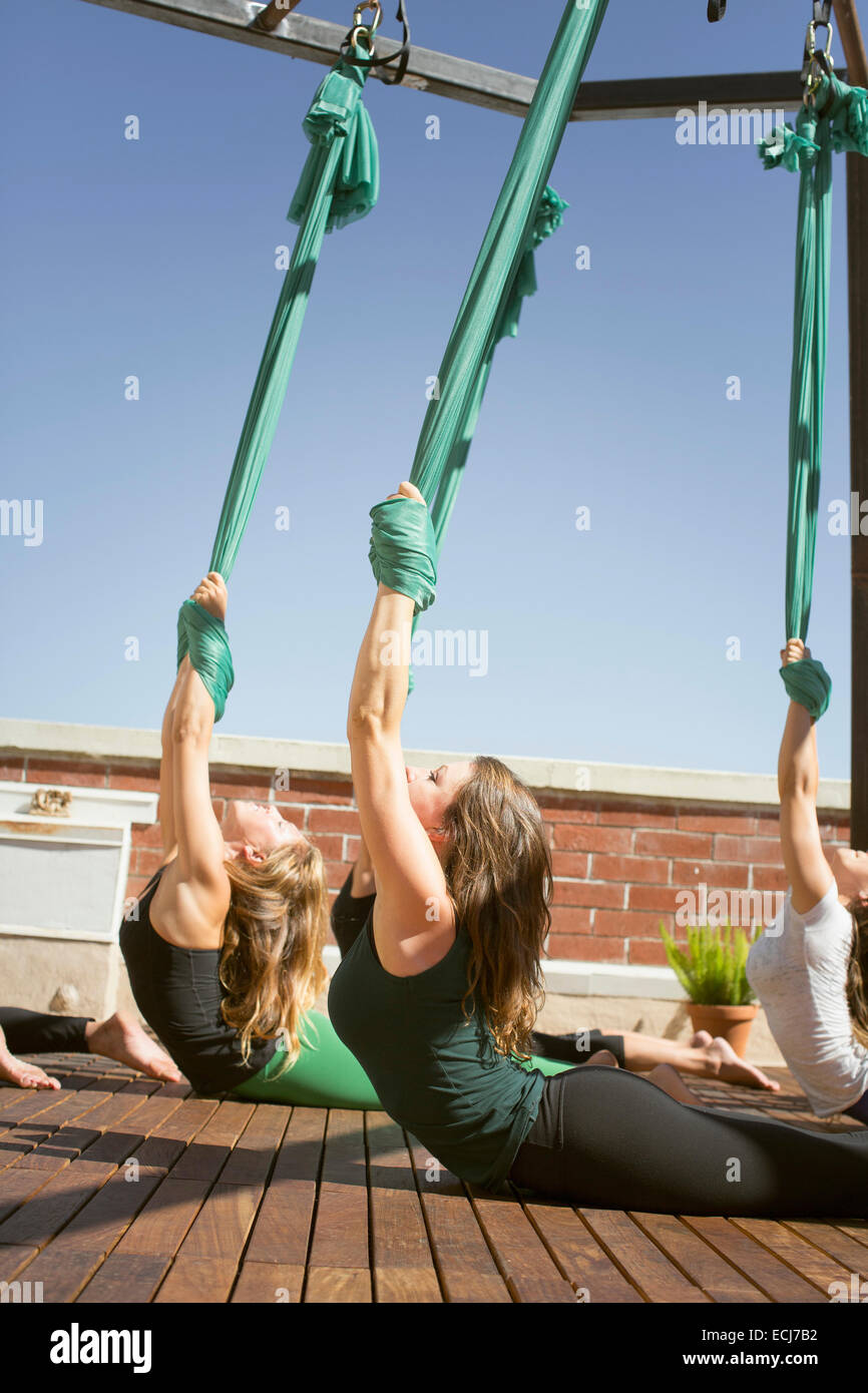 Un grupo de mujeres realiza yoga aérea. Foto de stock