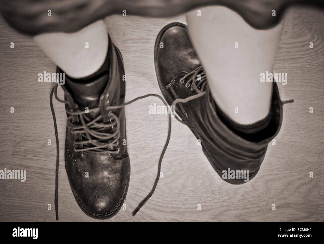 Fotografía en tonos sepia de una mujer de piernas en botas, una pierna gira  hacia el otro lado como si ella tiene dos pies izquierdo Fotografía de  stock - Alamy