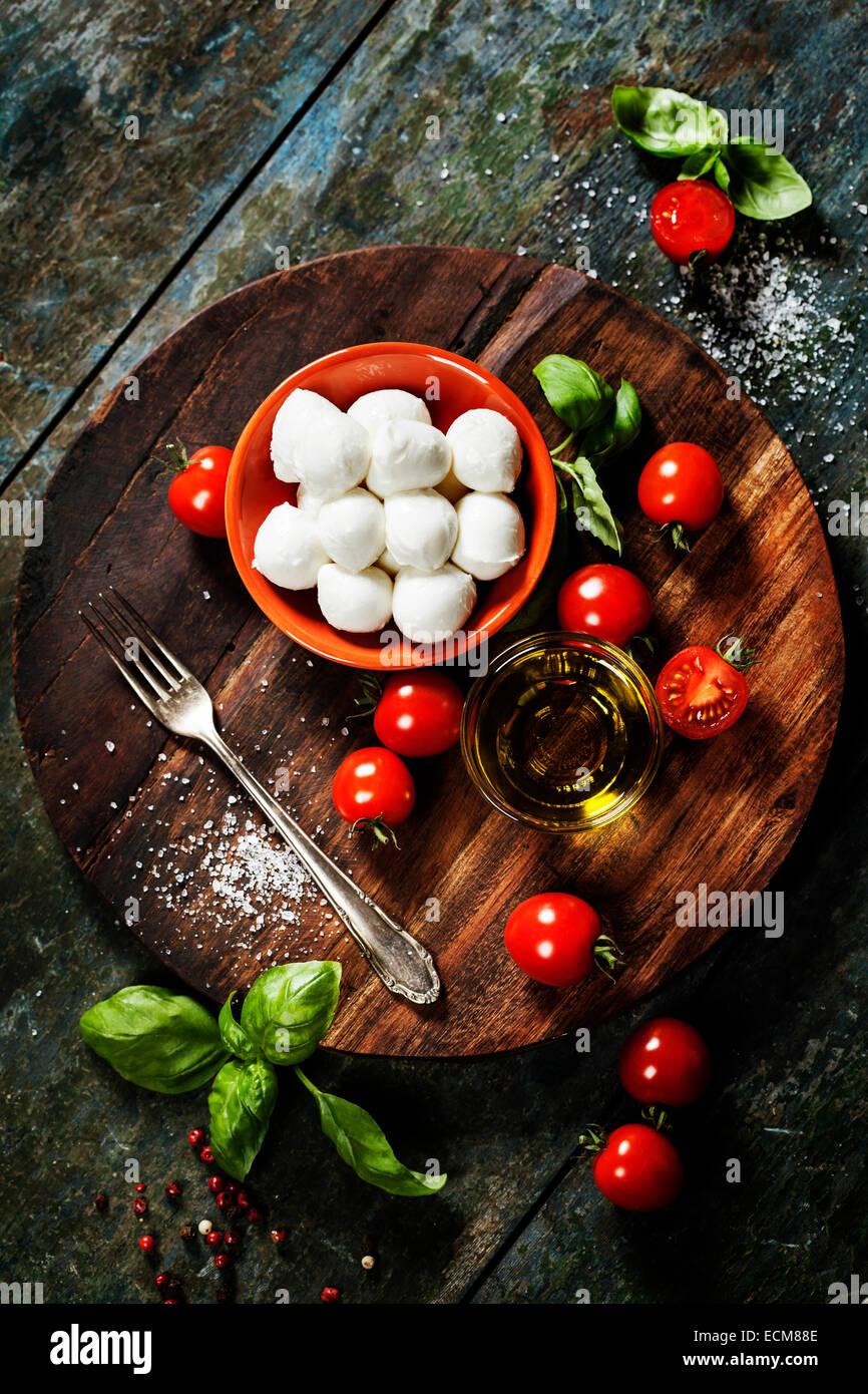 Tomates Cherry, albahaca, mozzarella y aceite de oliva para la ensalada Caprese. Un montón de espacio de copia Foto de stock