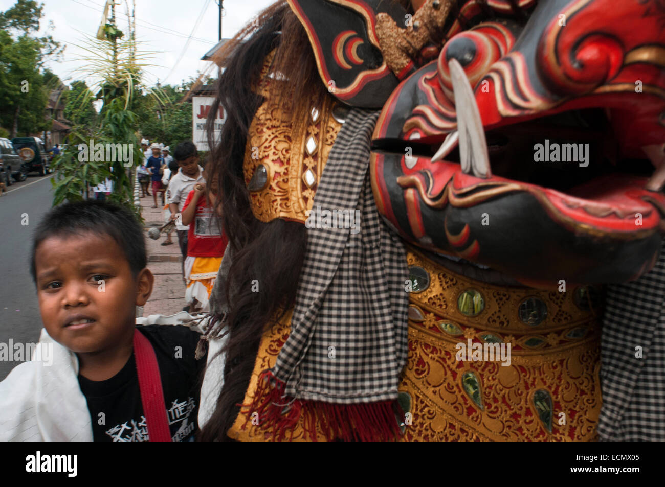 Varios jóvenes reproducir música y dragón disfrazados por las calles de Ubud, durante la celebración de Galungan. Festival Galungan, la más importante de Bali, simboliza la victoria de Drama (virtud) sobre Adharma (mal). Durante los días que el último desfile balinés celebraciones en toda la isla, adornado con largas varas de bambú (penjor) decorada con mazorcas de maíz, coco, tortas de arroz y pastelitos, así como telas blancas o amarillas, frutas, flores. Este festival se celebra cada 210 días. Ubud. Bali. Foto de stock