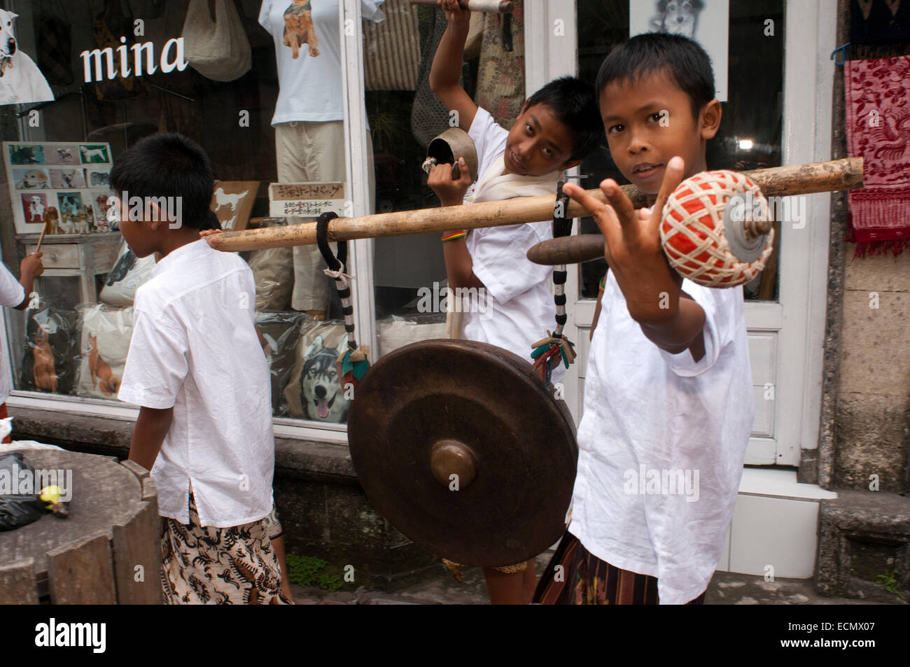Varios jóvenes reproducir música y dragón disfrazados por las calles de Ubud, durante la celebración de Galungan. Festival Galungan, la más importante de Bali, simboliza la victoria de Drama (virtud) sobre Adharma (mal). Durante los días que el último desfile balinés celebraciones en toda la isla, adornado con largas varas de bambú (penjor) decorada con mazorcas de maíz, coco, tortas de arroz y pastelitos, así como telas blancas o amarillas, frutas, flores. Este festival se celebra cada 210 días. Ubud. Bali. Foto de stock