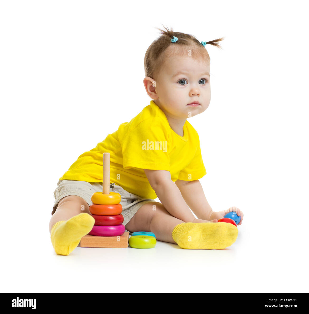 Bebé niña jugando con coloridos pirámide aislado en blanco Foto de stock