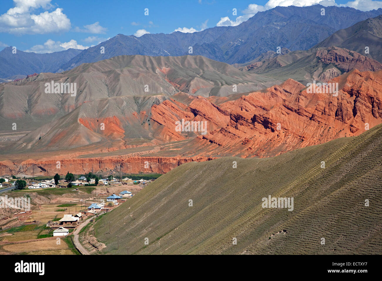 Aldea entre montañas coloridas, estribaciones de los Himalayas en la provincia de Osh, Kirguistán Foto de stock