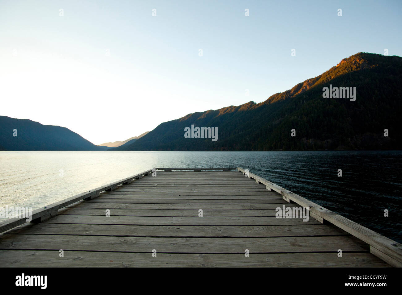 Deck de madera en el lago bajo un cielo azul Foto de stock