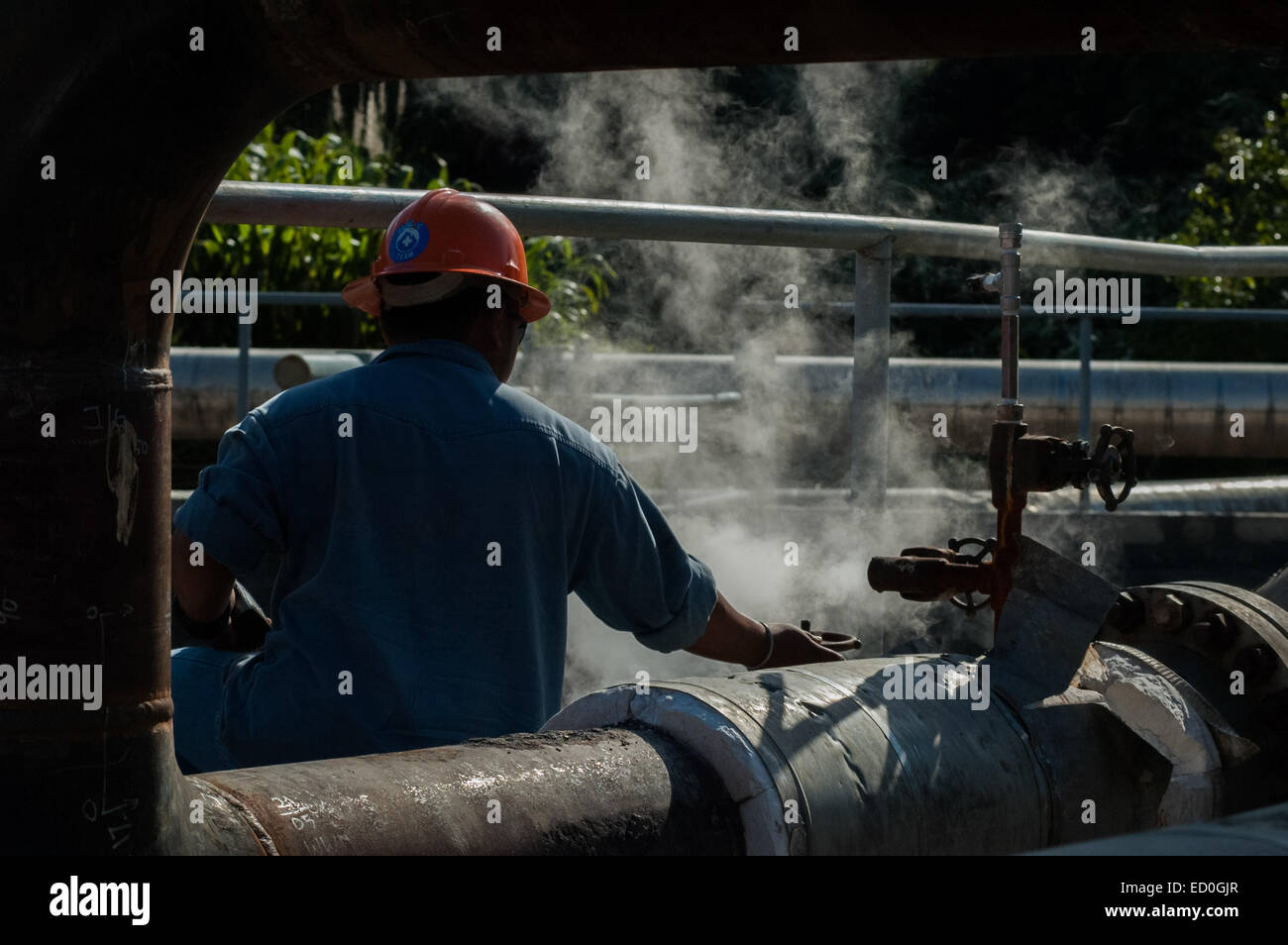 Un trabajador que comprueba la presión de gas del gasoducto en la instalación del área de concesión geotérmica de Chevron en Mount Salak, West Java, Indonesia. Foto de stock