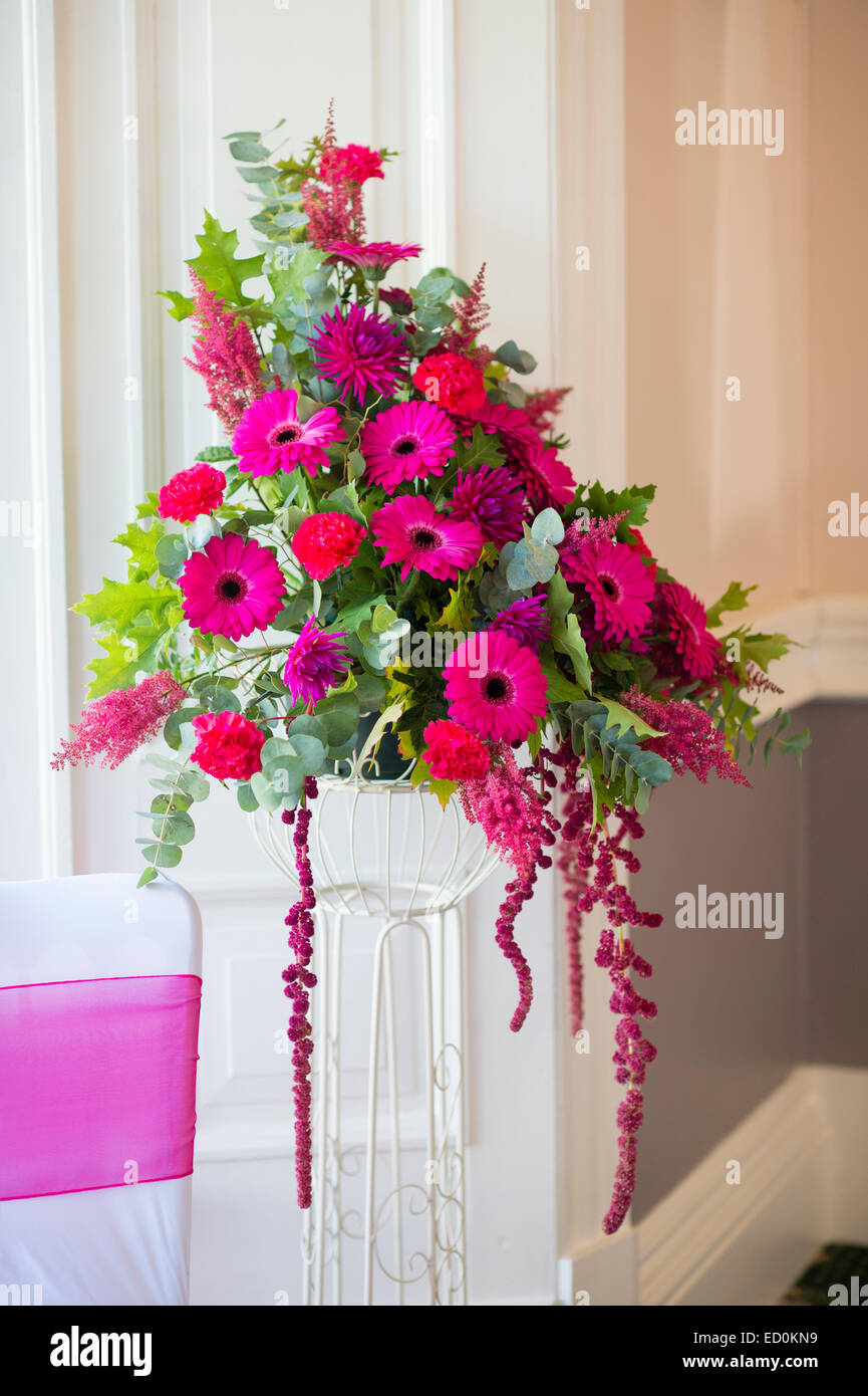 Día de la boda en el REINO UNIDO: un arreglo floral de gerberas rosas color  fucsia en el lugar de recepción Fotografía de stock - Alamy