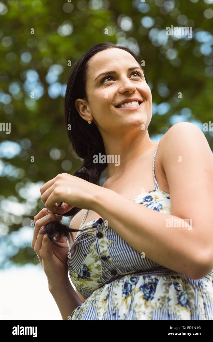 Retrato de una morena sonriente sosteniendo su trenzado Foto de stock