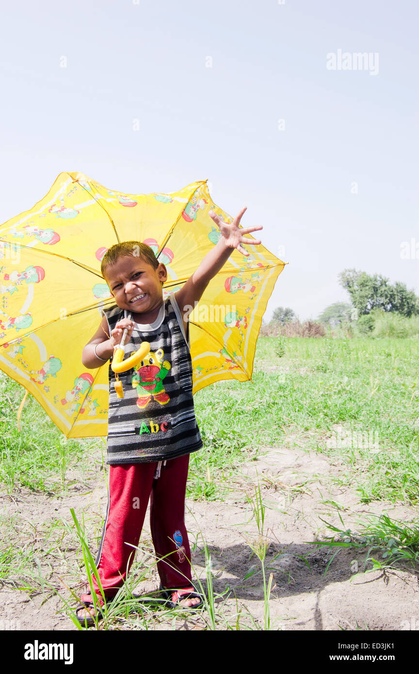 1 niño rural indio niño sosteniendo paraguas lluvia disfrutar Foto de stock