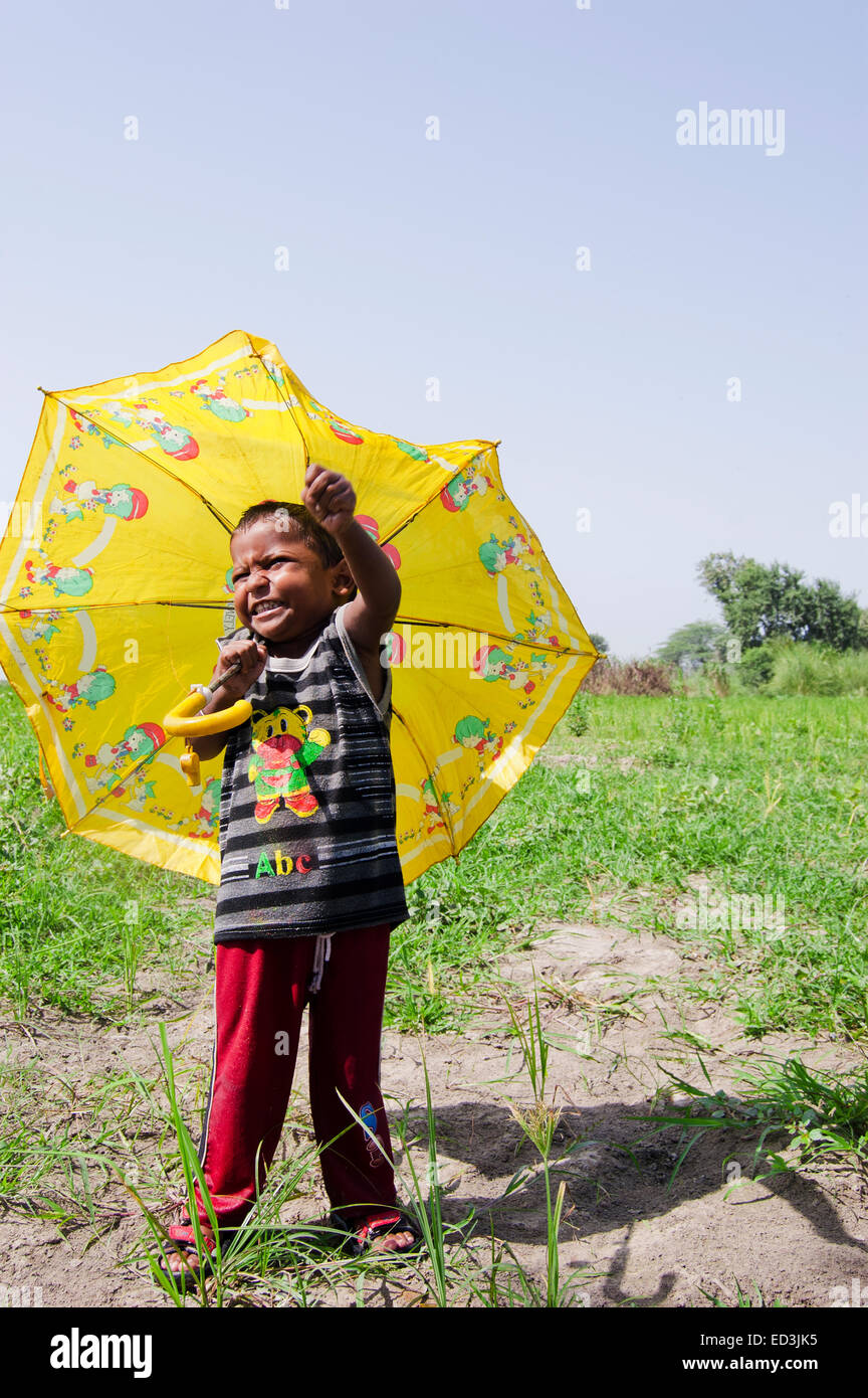 1 niño rural indio niño sosteniendo paraguas lluvia disfrutar Foto de stock