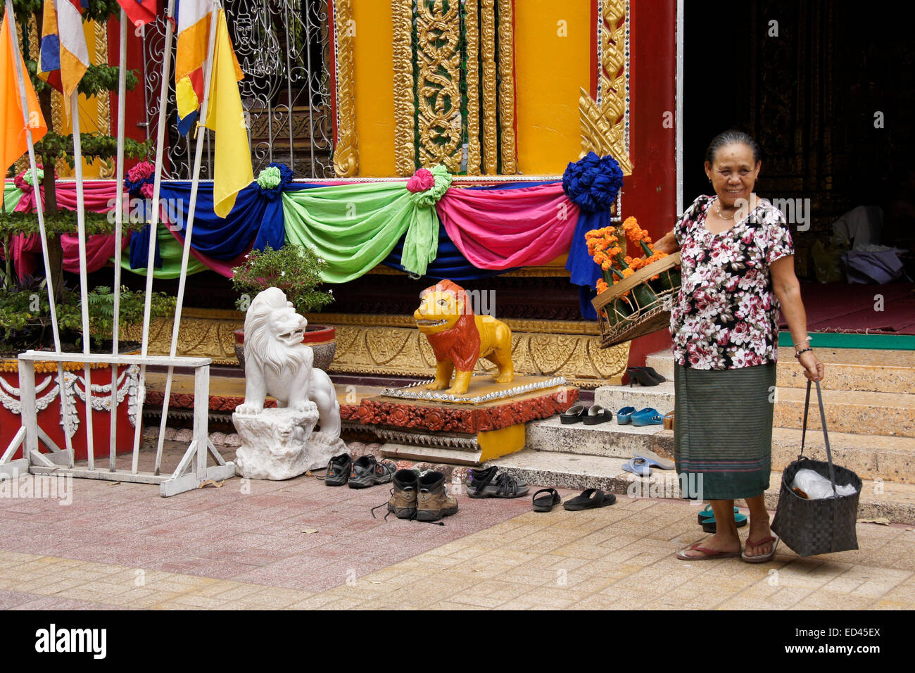 Mujer vendiendo flores en el Wat Si Muang templo budista, en Vientiane, Laos Foto de stock
