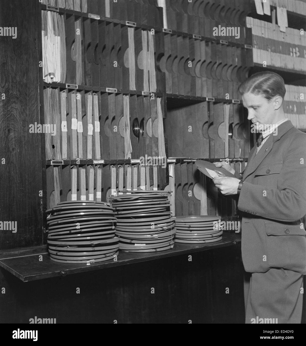 Archivos de sonido un hombre desconocido maneja cintas en la biblioteca de cinta Foto de stock