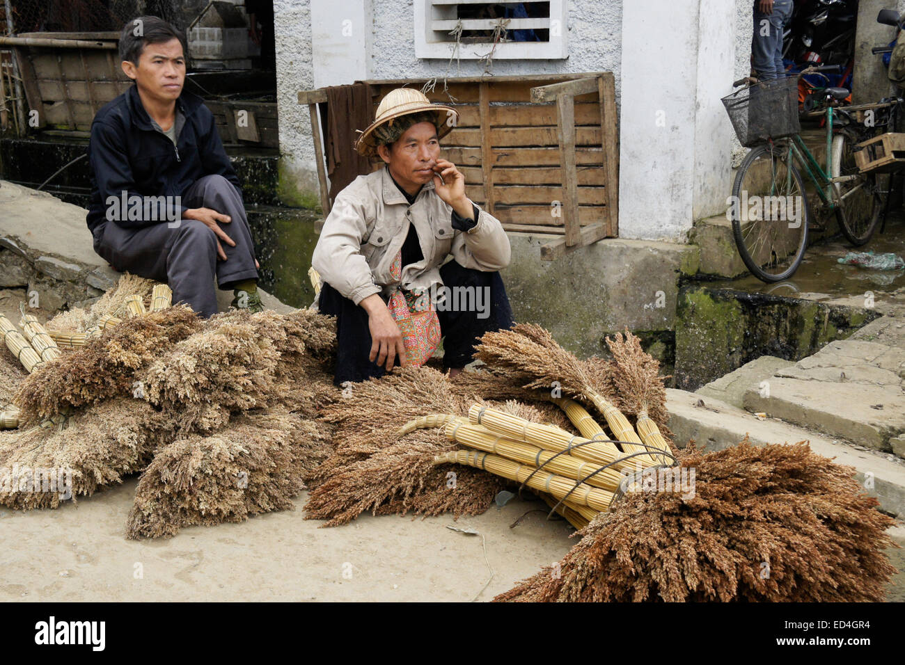 Hombres vendiendo escobas en el Mercado Dominical, Bac Ha, Sapa Sa (Pa), Vietnam Foto de stock