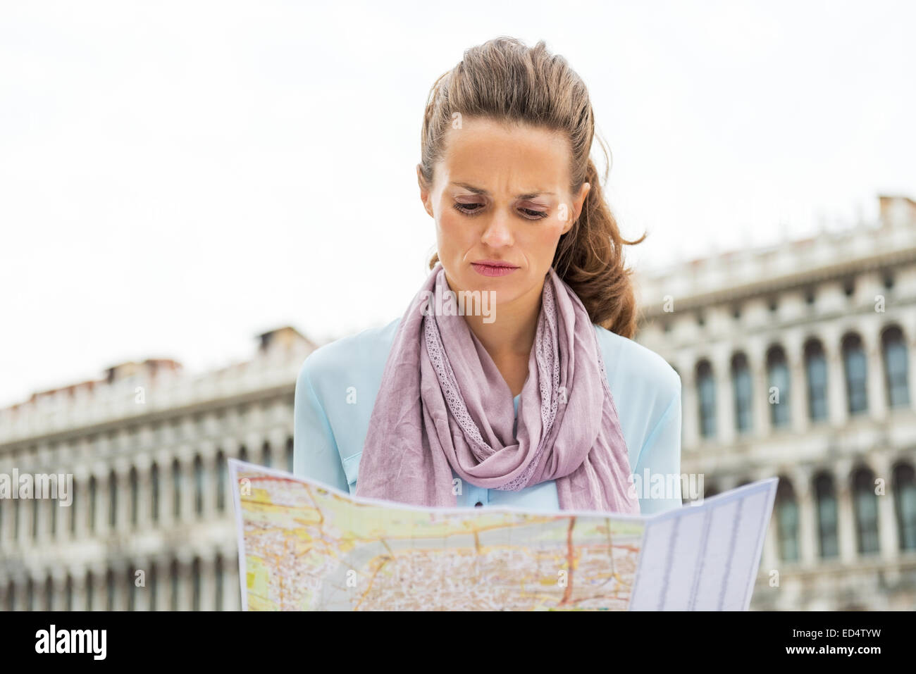 Mujer joven busca en el mapa en la plaza de San Marcos en Venecia, Italia Foto de stock