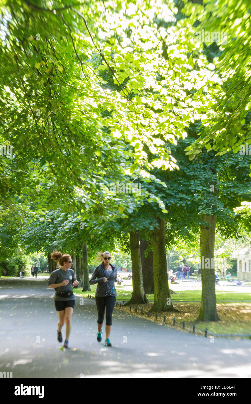 Dos mujeres correr a través de San Stephen's Green Park, Dublín. Foto de stock