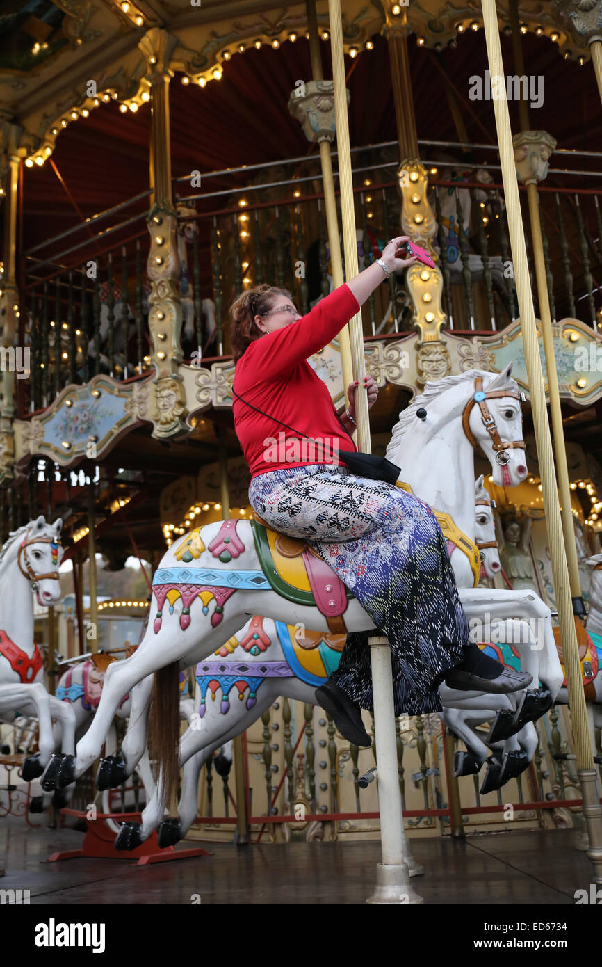 Grasa sobrepeso obsesionada mujer caballo carrusel merry go round Foto de stock