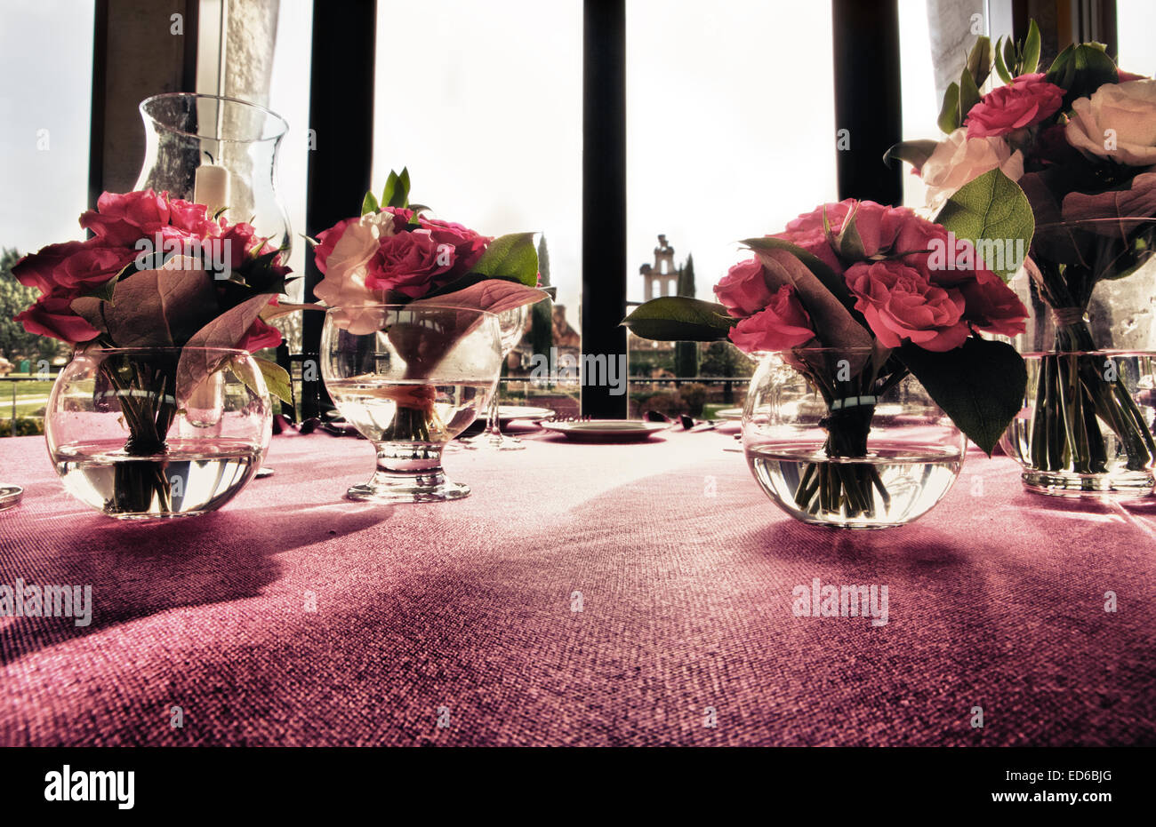 jarrones altos con hermosas flores artificiales en la mesa y el