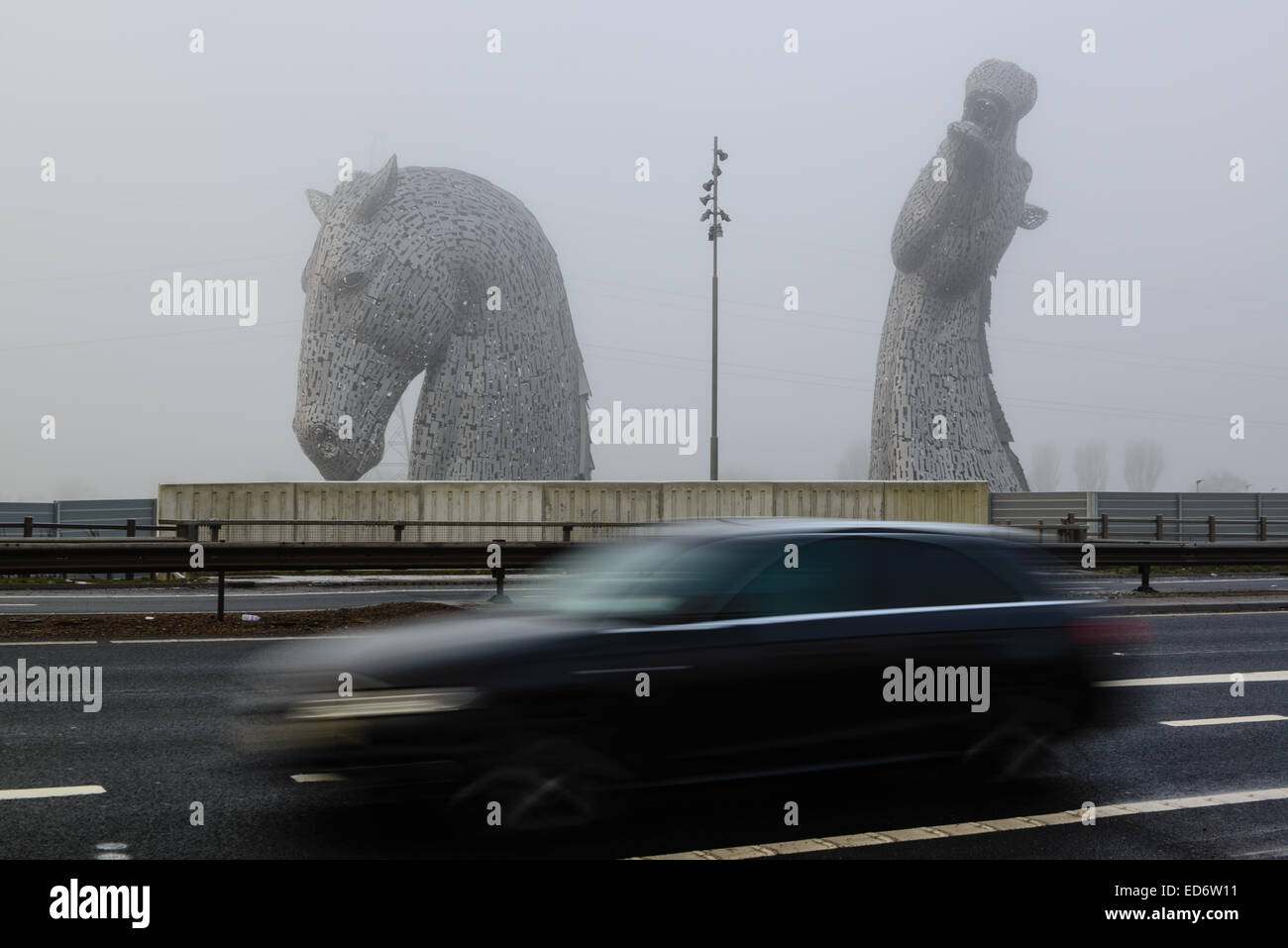 Los Kelpies aparecen de la niebla helada.Los Kelpies son de 30 metros de alto con cabeza de caballo,esculturas de pie junto a la autopista M9. Foto de stock