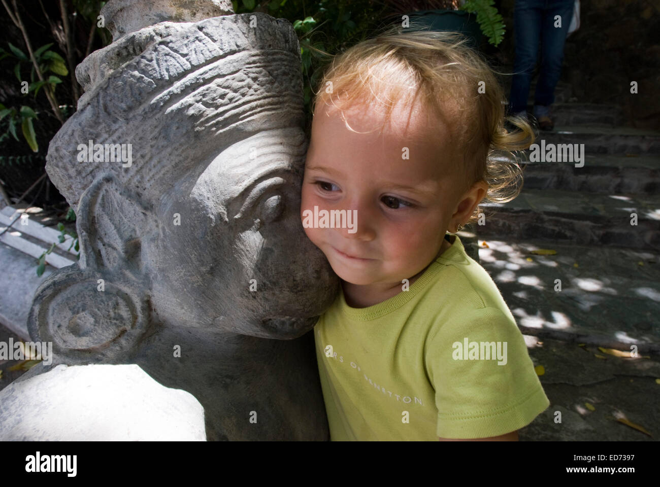 Niño posando junto a una de las esculturas y estatuas del Palacio Real. Phnom Penh. Camboya. Asia. Viajar con niños. Chica Foto de stock