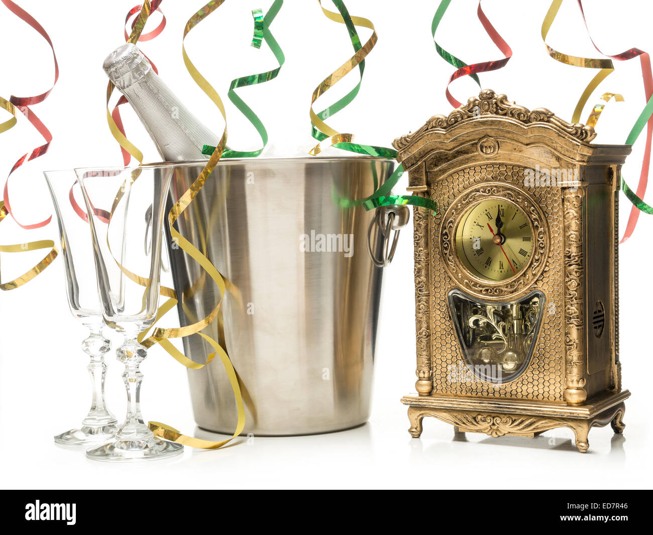 Año nuevo botella de champaña en el refrigerador, dos copas de champaña y tabla reloj mostrando la medianoche rodada en blanco Foto de stock