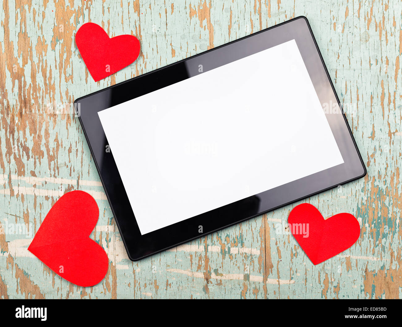 El Día de San Valentín de espacio de copia en digital tablet PC con pantalla en blanco y rojo corazones de papel viejo grunge textura de madera. Foto de stock