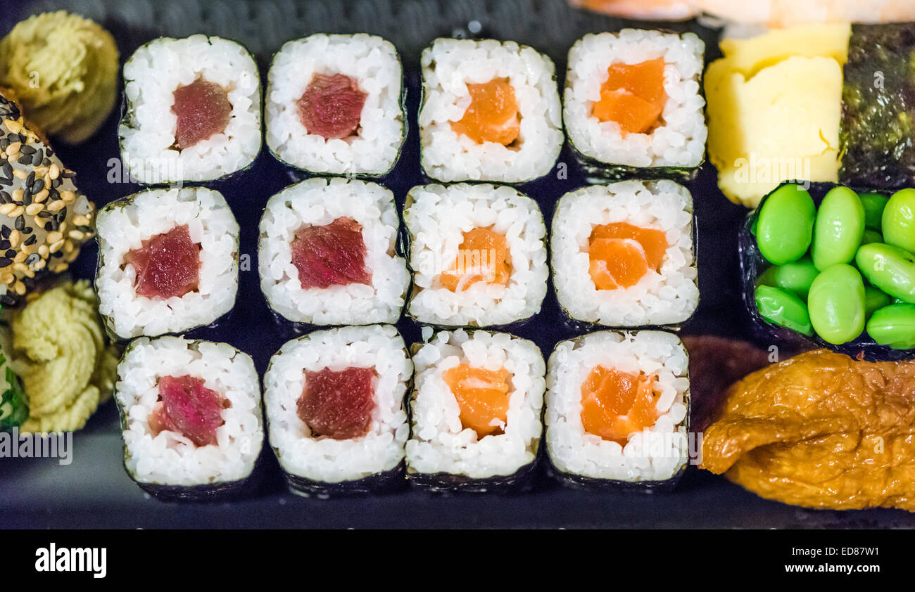 Plato de sushi con laminados Makizushi (sushi), verde edamame frijoles y Inarizushi Foto de stock