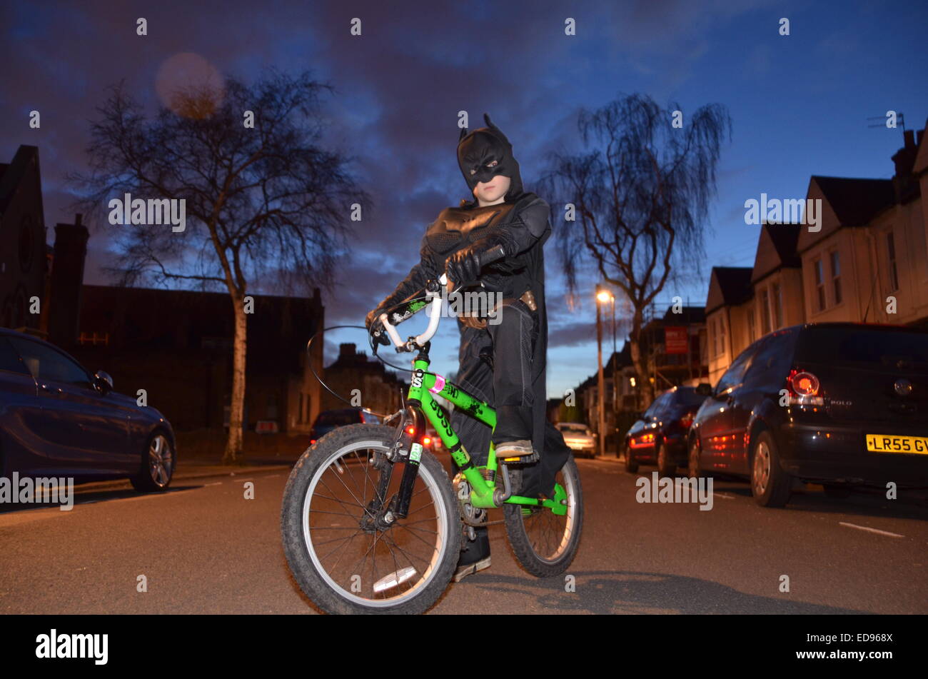 Chico en Batman disfraces en bicicleta cielo espectacular carretera súper  héroe Fotografía de stock - Alamy