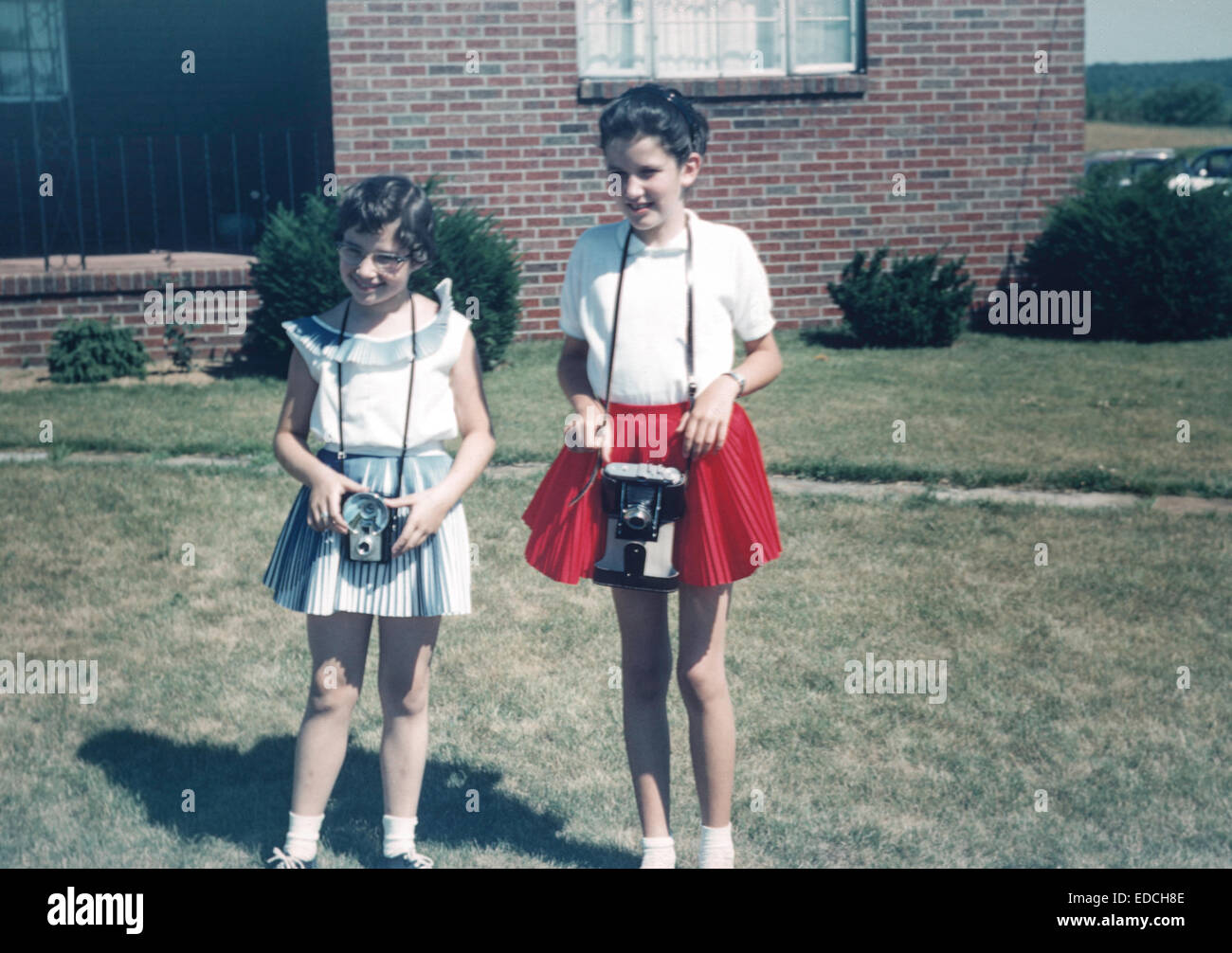 Imagen vintage de dos niñas posando con cámaras, 1950 Foto de stock
