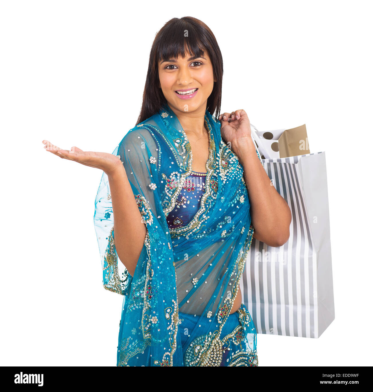 Hermosa mujer india en ropas tradicionales llevando bolsas de compras sobre fondo blanco. Foto de stock