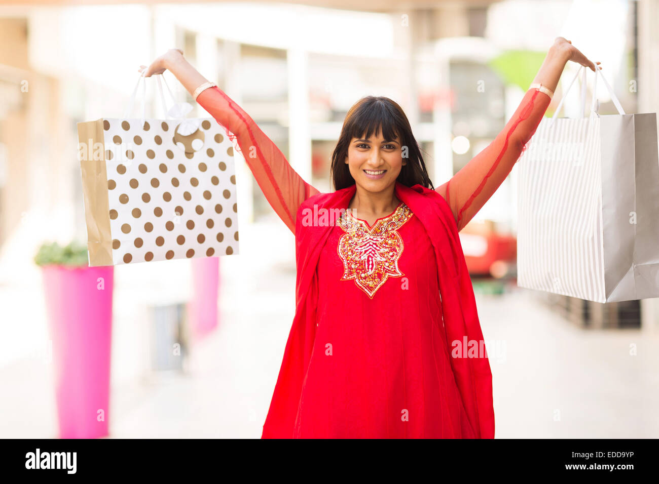 Mujer India feliz celebración bolsas de compras en mall Foto de stock