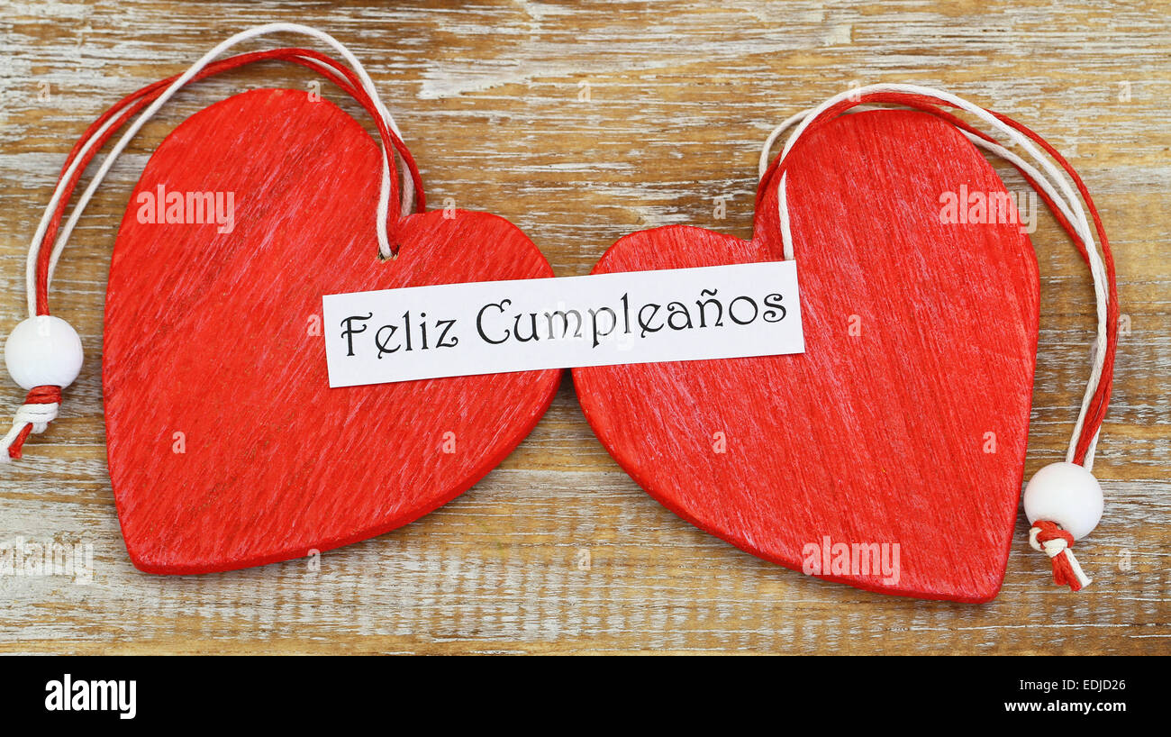 Feliz Cumpleanos Que Significa Feliz Cumpleanos En Espanol Con Dos Corazones De Madera Roja Fotografia De Stock Alamy