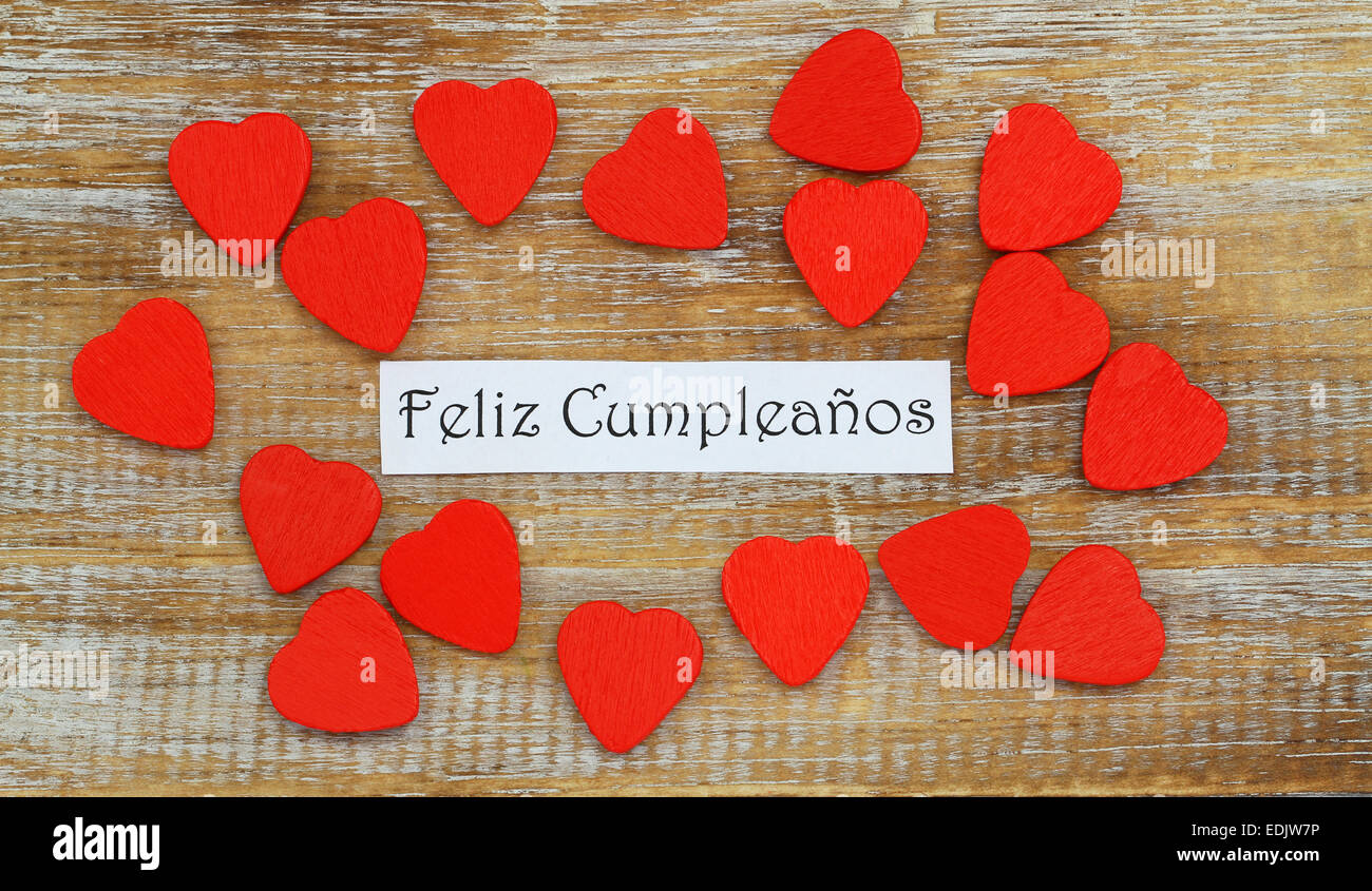 Feliz Cumpleanos (que significa Feliz Cumpleaños en español) con pequeños  corazones de madera roja Fotografía de stock - Alamy