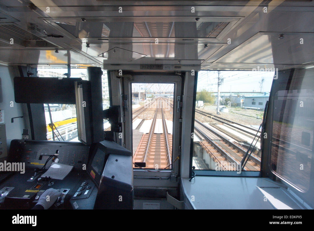 Vista interior, frente al tren japonés de desplazamiento de los conductores taxi y la vista exterior delante de las vías de tren como el tren velocidades a través de la ciudad. Foto de stock