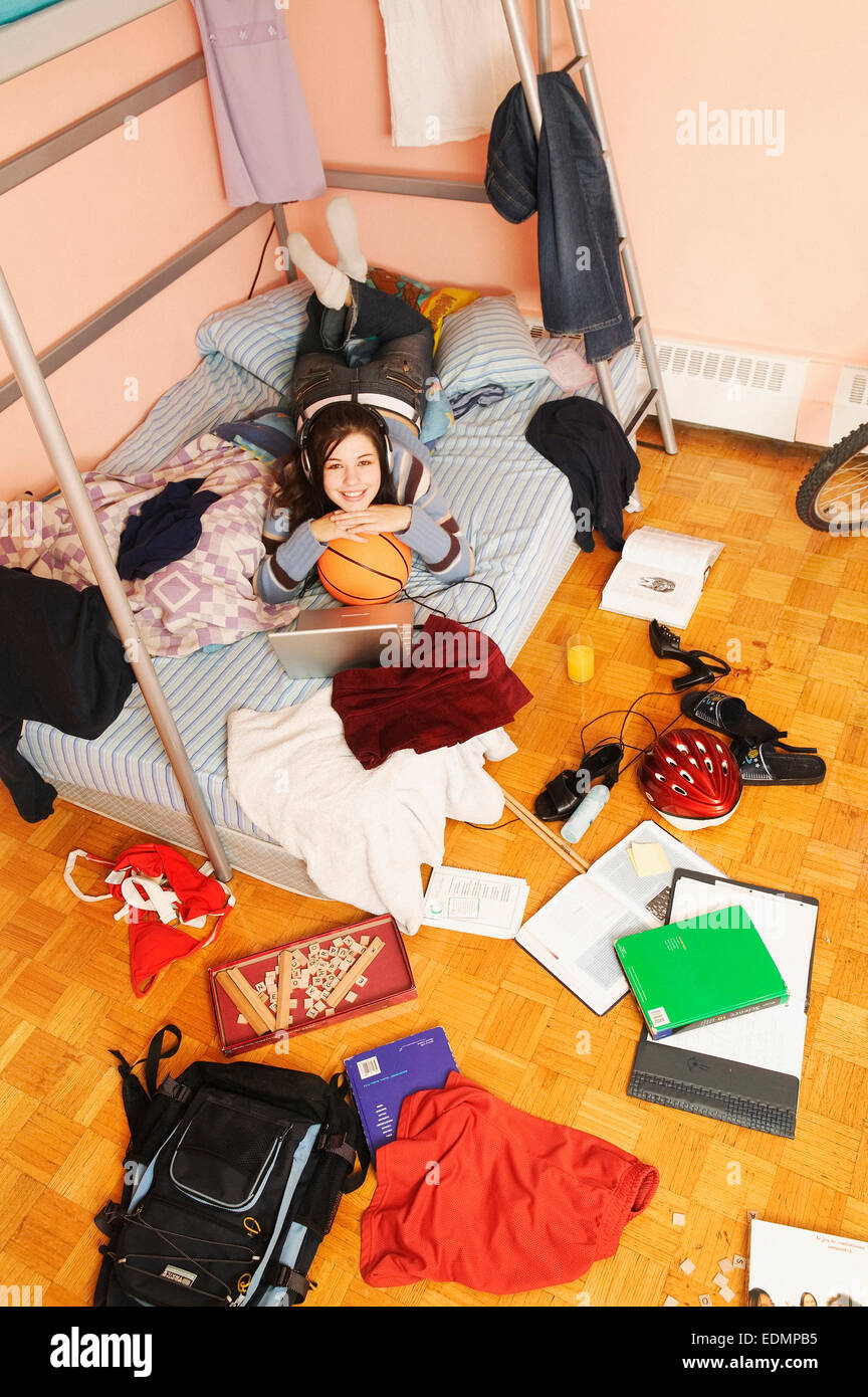 Adolescente relajante en su habitación desordenada Foto de stock