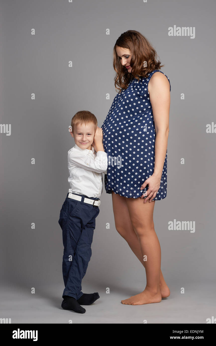 Abrazo muchacho joven madre embarazada Foto de stock