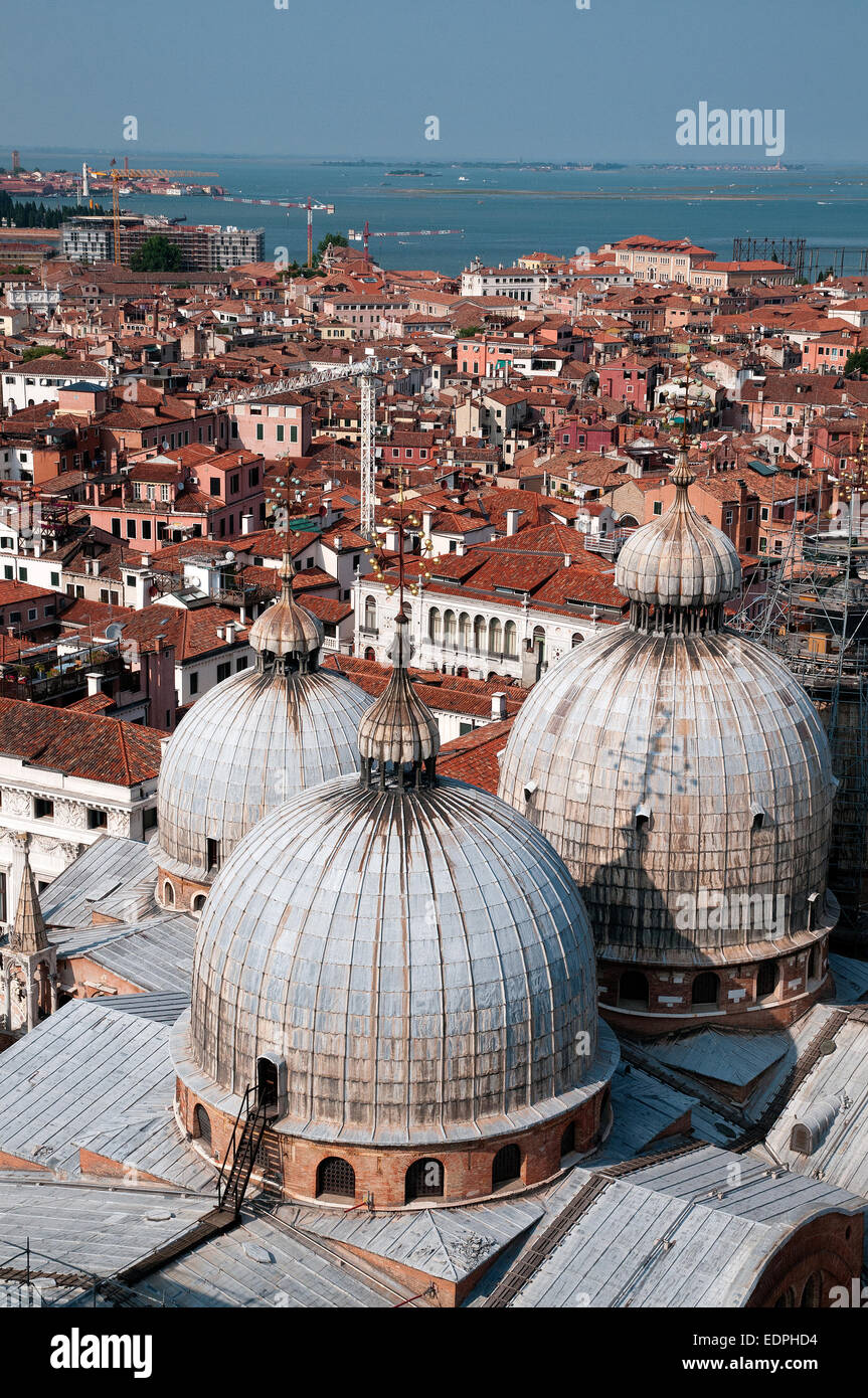 Las cúpulas de la Basílica di San Marco, la Catedral de San Marcos vista desde lo alto de la torre campanario de San Marcos en Venecia, Italia, con el mar más allá de las cúpulas BASILI Foto de stock