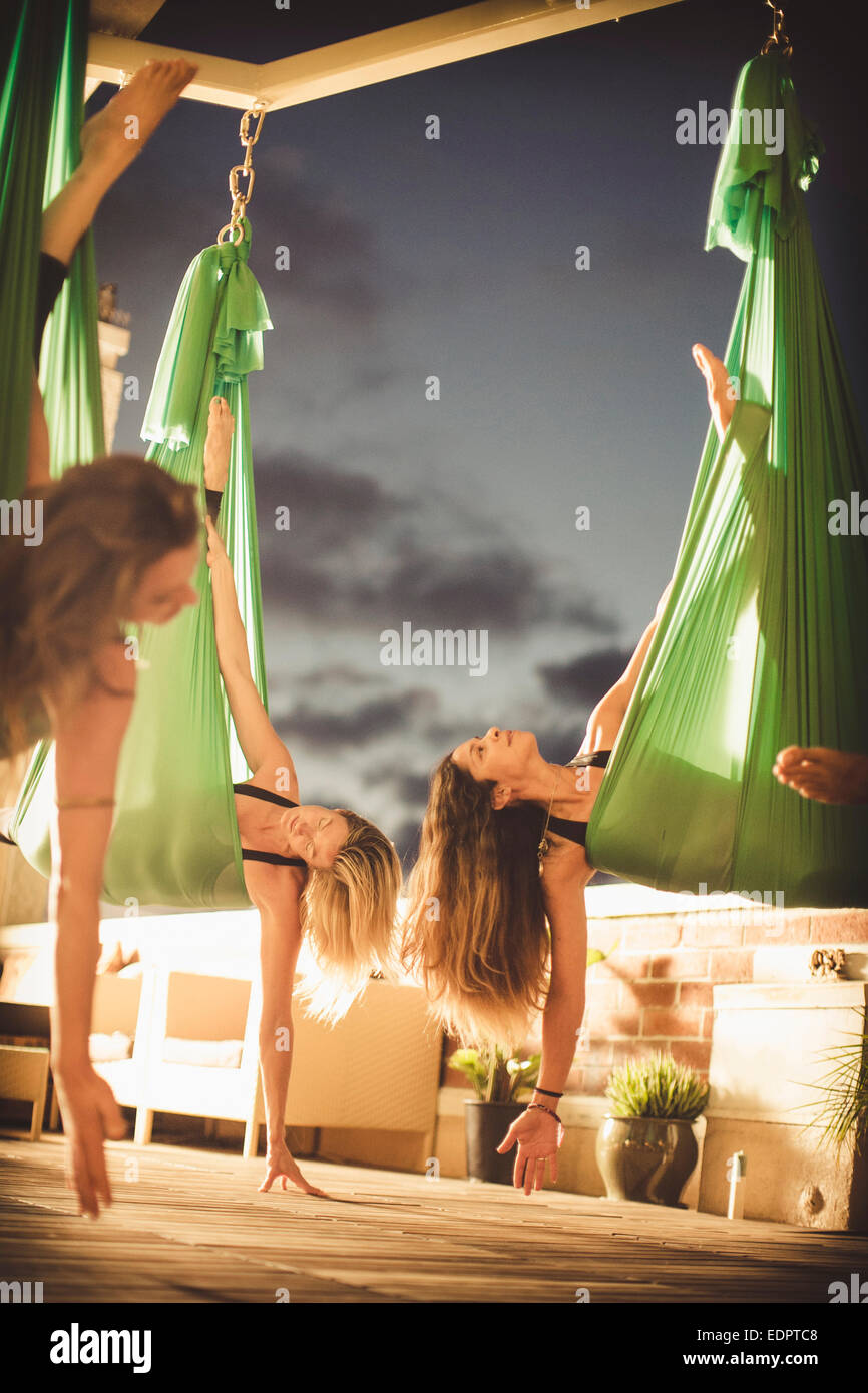 Tres chicas jóvenes realizar yoga aérea. Foto de stock