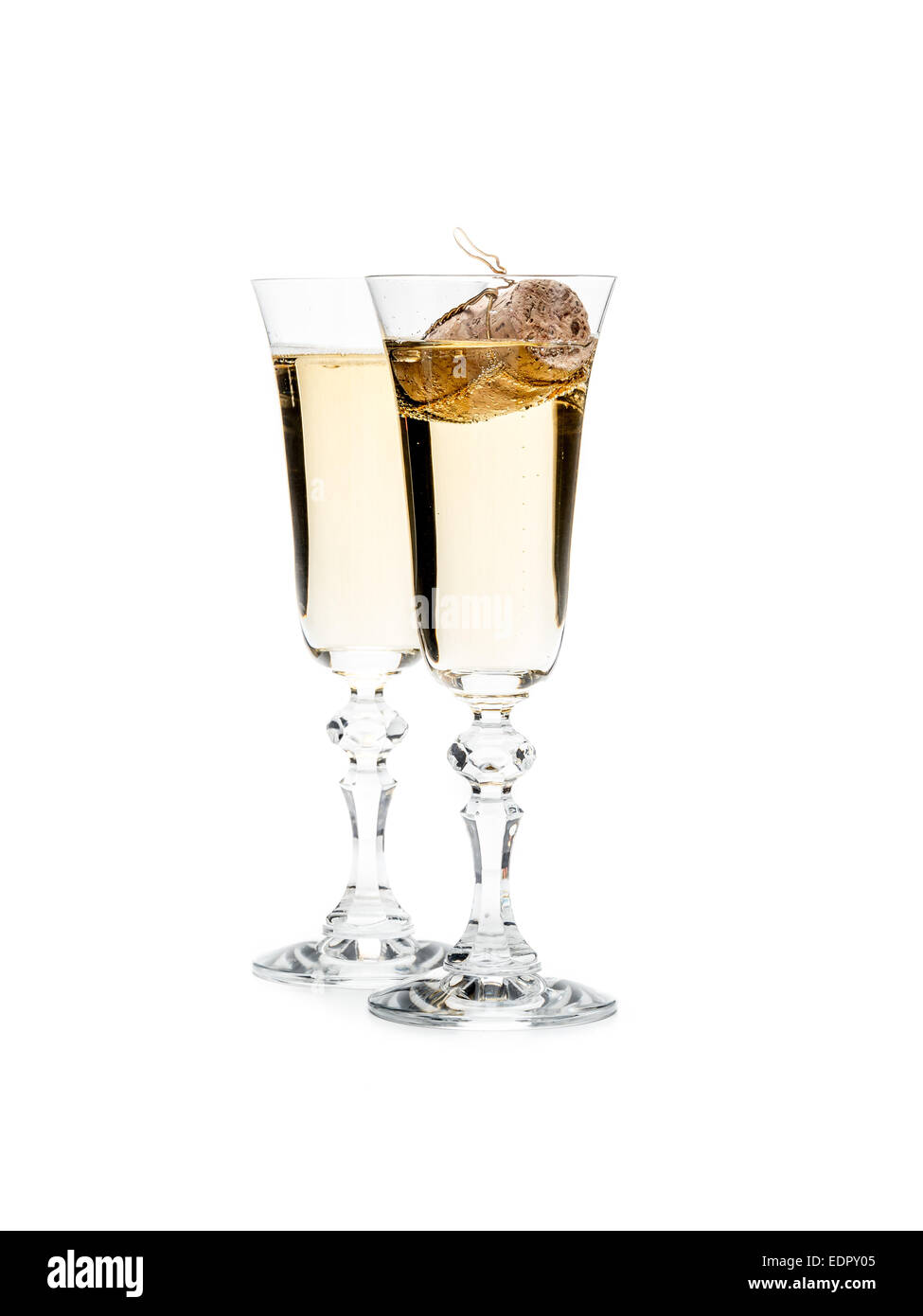 Dos copas de champaña con champán corcho flotando en un vaso shot sobre blanco Foto de stock