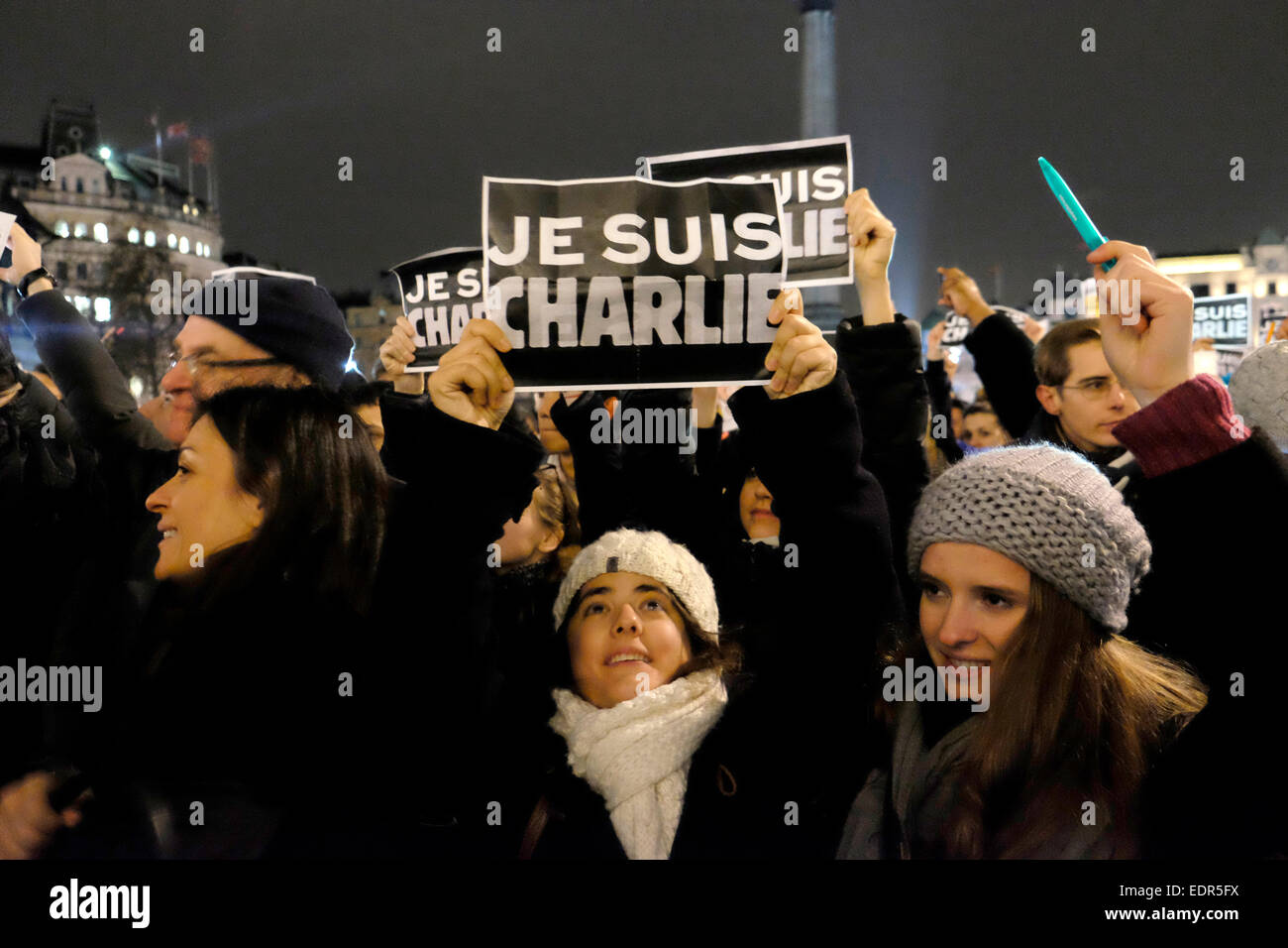 Una mujer sostiene un cartel que dice "Je suis Charlie', se traduce a soy Charlie. Foto de stock