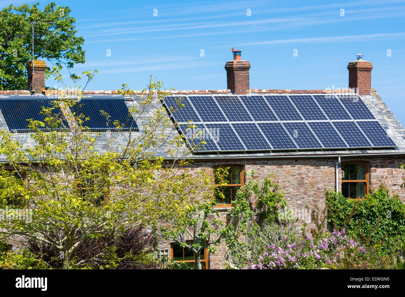 Paneles solares en la azotea y intercambiador de calor para el agua caliente en una propiedad de época en Occidente Tosberry, Devon, en el sur de Inglaterra, Reino Unido. Foto de stock