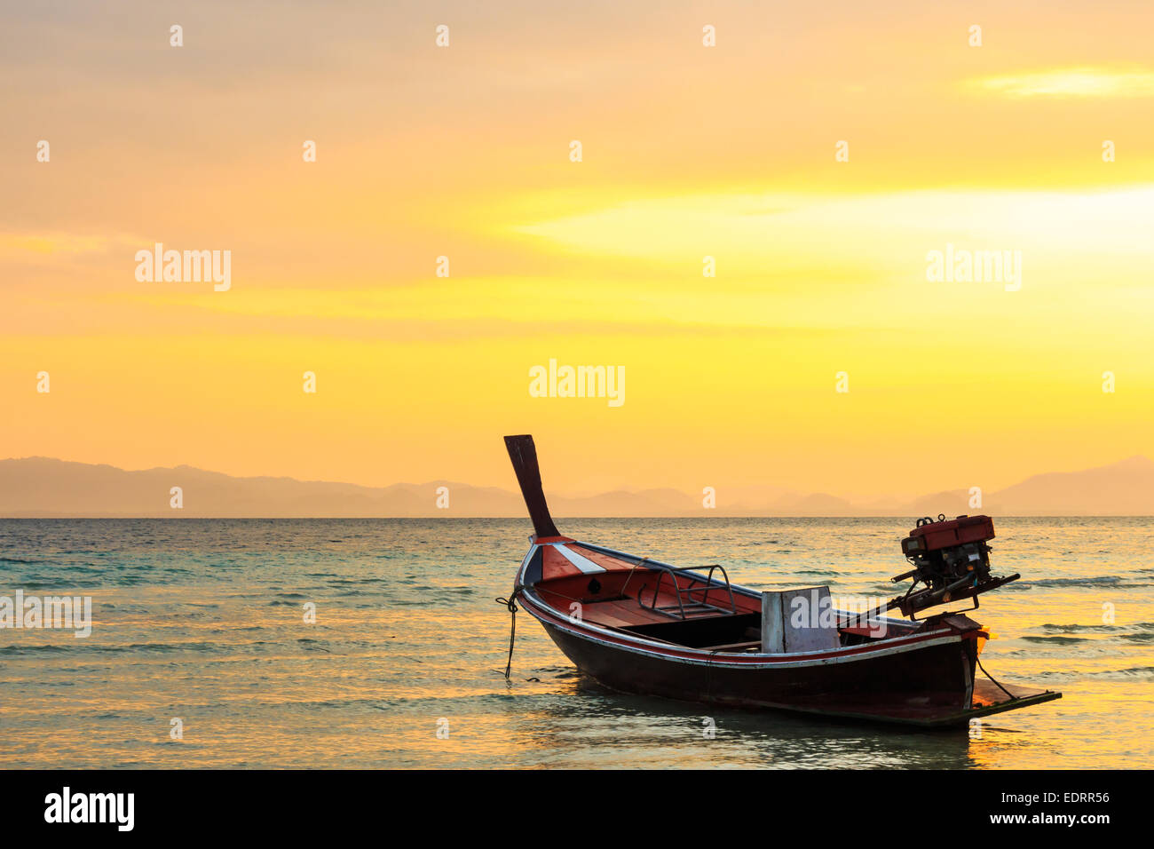 Barco nativo en la playa y el amanecer en la mañana en Trang ,Tailandia Foto de stock