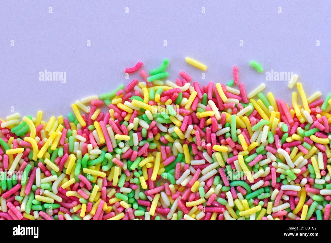 Colorido candy sprinkles adorne alimentos dulces topping sobre fondo blanco. Foto de stock