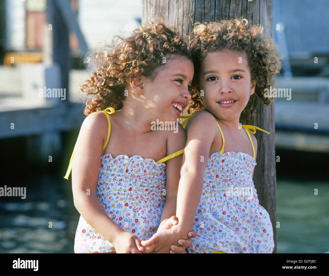 Dos jóvenes negros gemelos sentado en un muelle en la isla Padre, Texas Foto de stock
