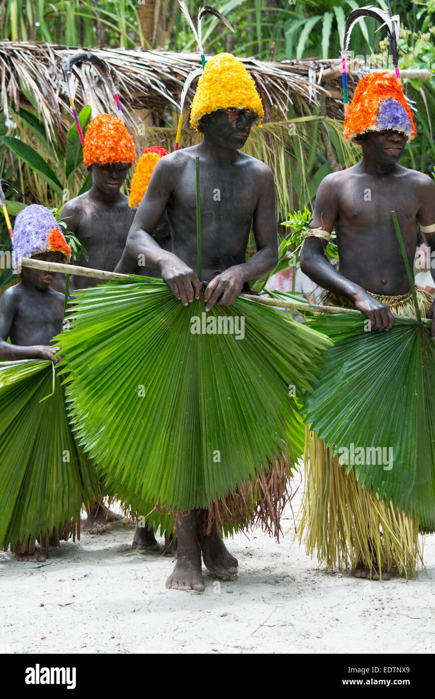 La República de Vanuatu, las Islas Torres, Loh Island. Danza ceremonial en la lluvia con las murgas de niños en coloridos tocados. Foto de stock