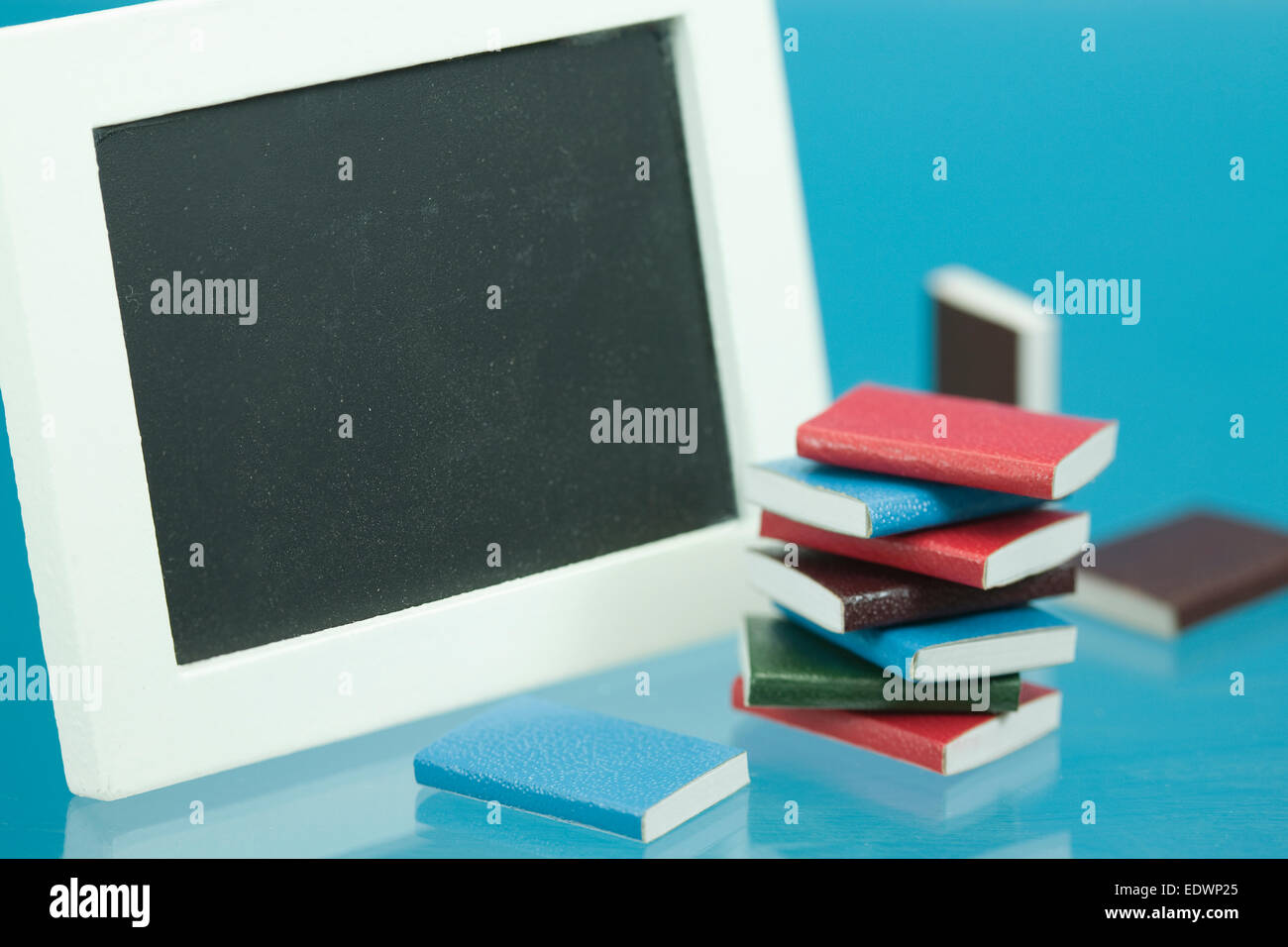 Concepto de regreso a la escuela con los libros escolares en miniatura y blackboard Foto de stock
