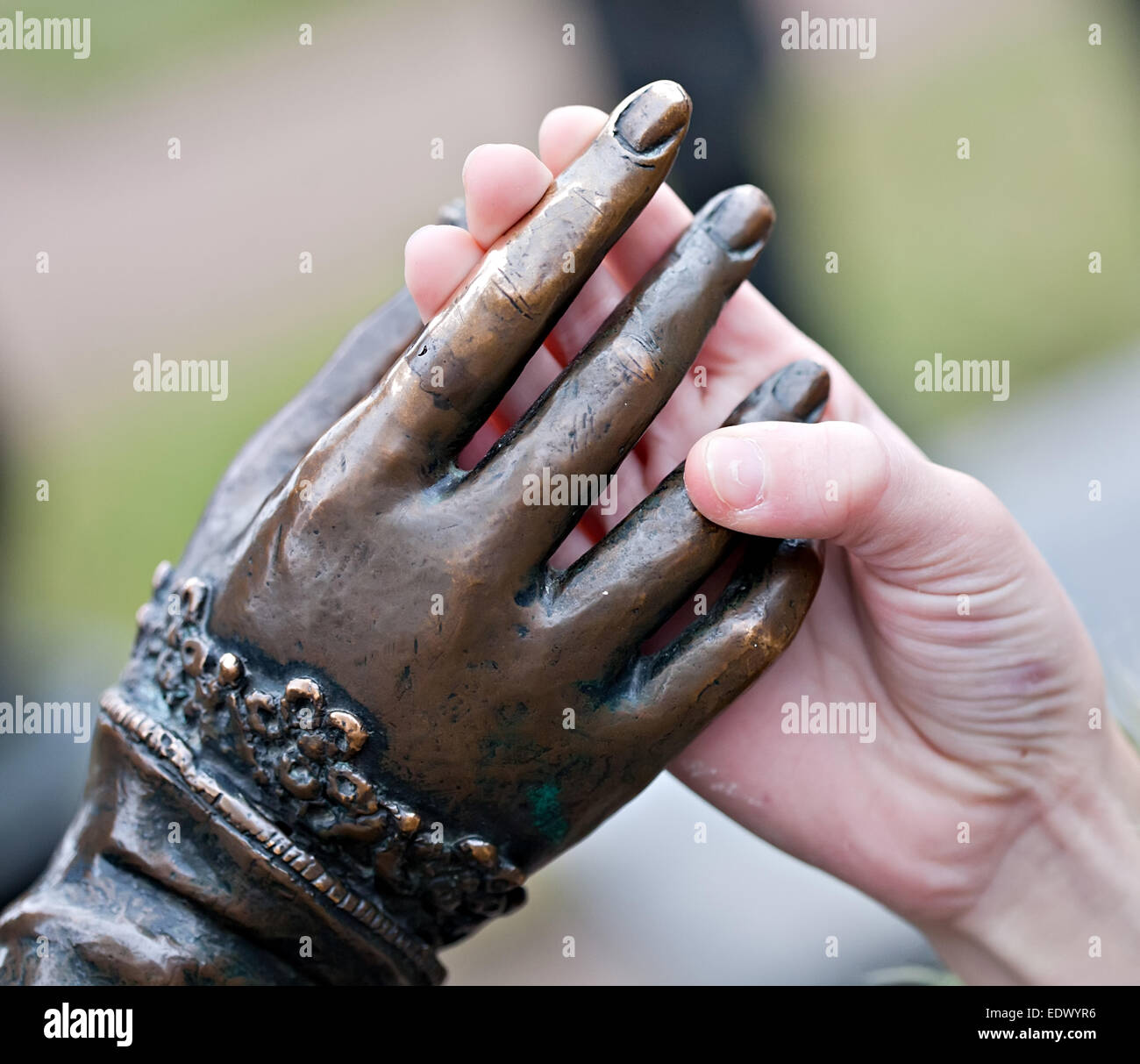 Toque acercamiento de las dos manos: estatua de metal y derechos niño Foto de stock