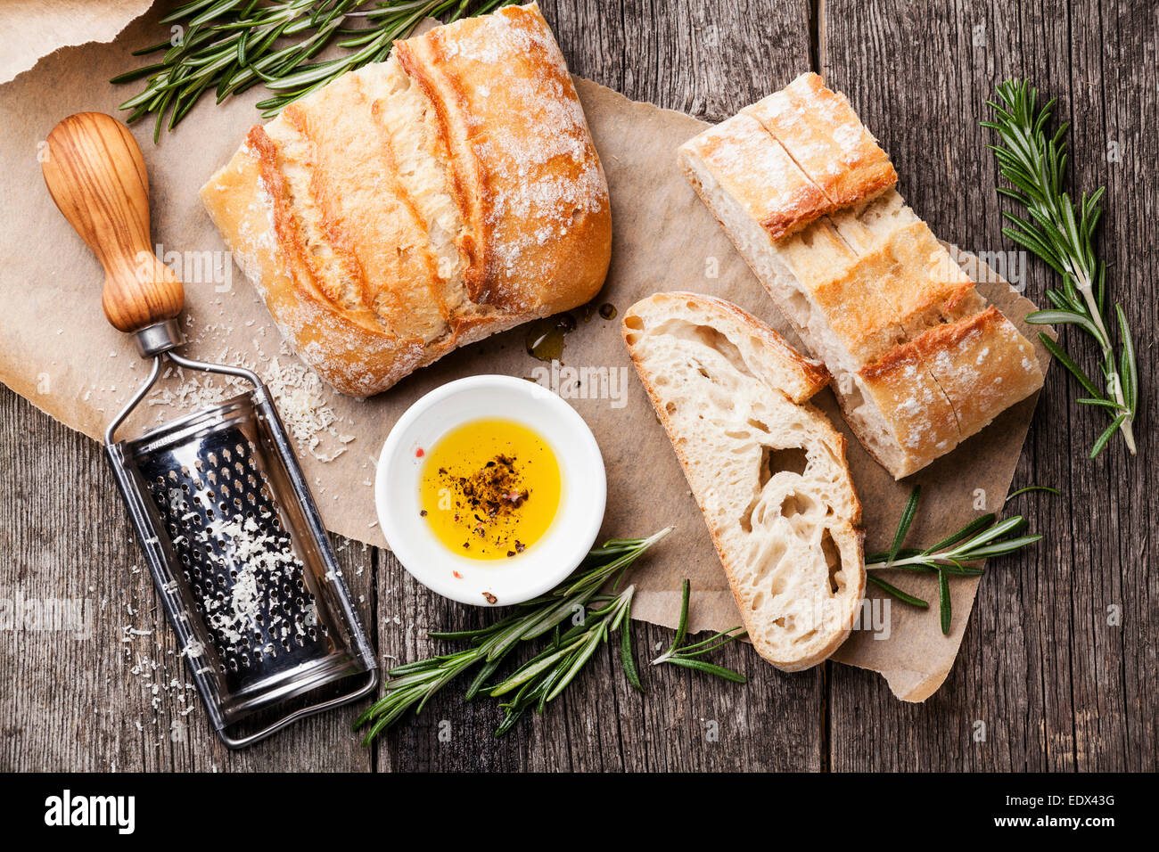Rebanadas de pan ciabatta y aceite de oliva virgen extra en el fondo de madera Foto de stock