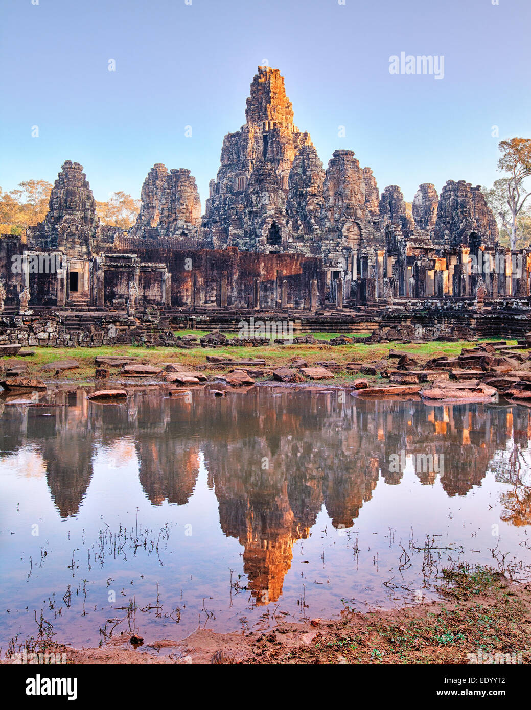 Templo Bayon paisaje de amanecer. Reflexión sobre rostros tallados en el lago Foto de stock