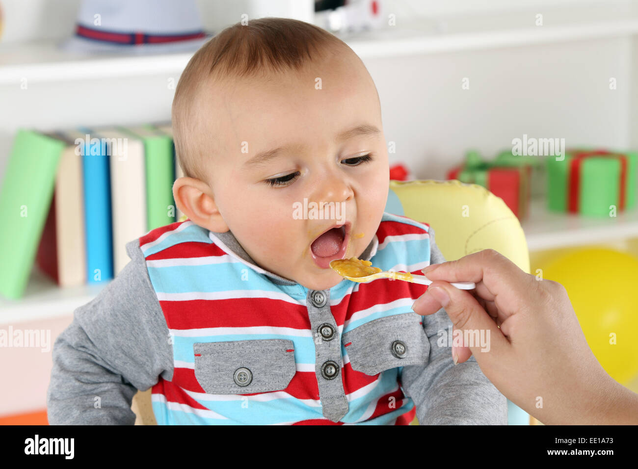 Madre alimentando lindo niño con alimentos para bebés Foto de stock