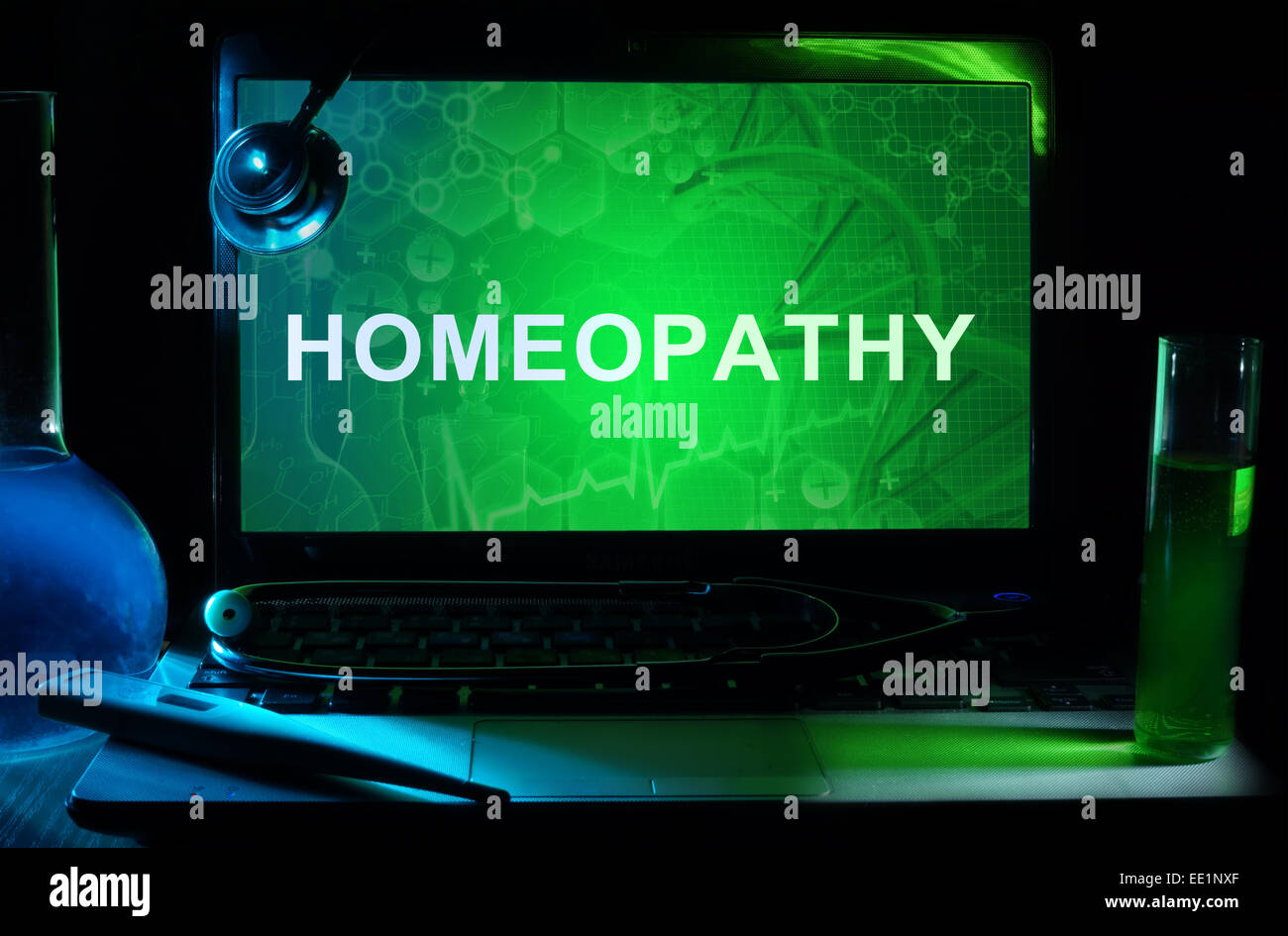 Portátil con palabras la homeopatía, tubos de ensayo y estetoscopio Foto de stock